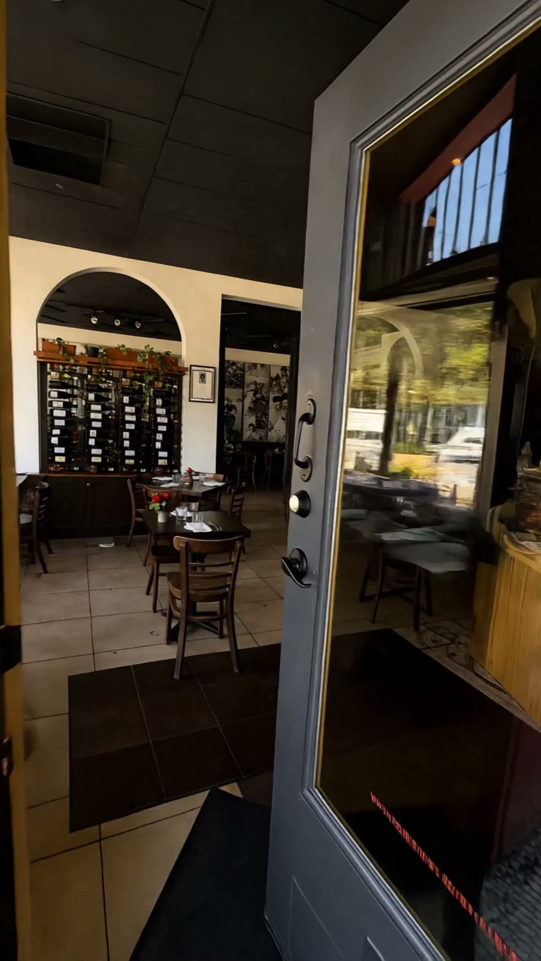 The dining room at Osteria Mamma: set tables, arched openings and warm lamplight.
